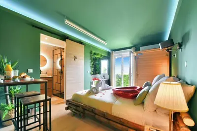 a bedroom with green walls and a large bed at The Jungle - Jacuzzi, Sauna & Projector in Cannes