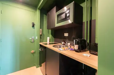 a kitchen with a sink and a green door at The Jungle - Jacuzzi, Sauna & Projector in Cannes