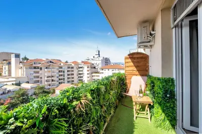 a balcony with a table and a view of a city at The Jungle - Jacuzzi, Sauna & Projector in Cannes