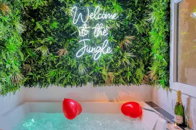 a swimming pool with red balloons and a sign on the wall at The Jungle - Jacuzzi, Sauna & Projector in Cannes