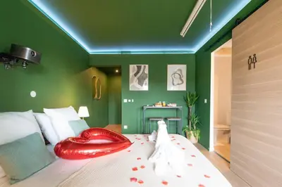 a bed with a large red heart shaped pillow on it at The Jungle - Jacuzzi, Sauna & Projector in Cannes