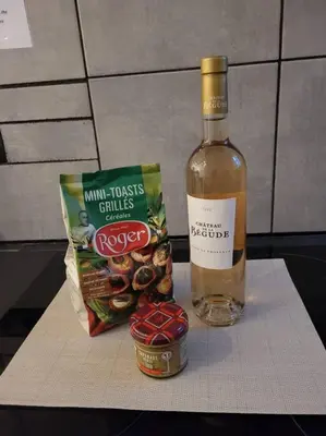 a bottle of wine next to a bag of food and a bottle of snacks at Villa Gustave, studio confort avec balcon Centre Cannes in Cannes