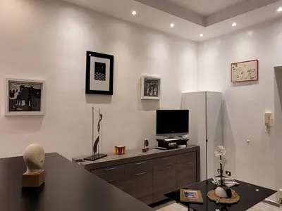 a living room with a television on a dresser at Villa Gustave, studio confort avec balcon Centre Cannes in Cannes