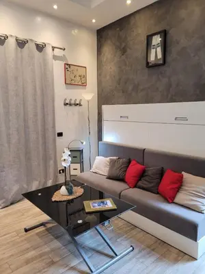 a living room with a couch and a table at Villa Gustave, studio confort avec balcon Centre Cannes in Cannes