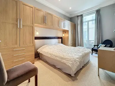 a bedroom with a bed and a chair and cabinets at Beautiful 2 bedroom bourgeois style Antibes 333 in Cannes