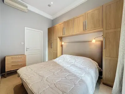 a bedroom with a bed and wooden cabinets at Beautiful 2 bedroom bourgeois style Antibes 333 in Cannes
