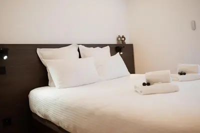 a large white bed with two stuffed animals on it at Moderne et Chic T3, à deux pas de la Croisette in Cannes