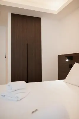 a bedroom with a white bed and a wooden door at Moderne et Chic T3, à deux pas de la Croisette in Cannes