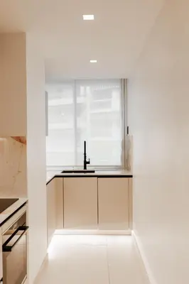 a white kitchen with a sink and a window at Moderne et Chic T3, à deux pas de la Croisette in Cannes