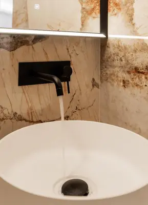 a white sink with water coming out of a faucet at Moderne et Chic T3, à deux pas de la Croisette in Cannes