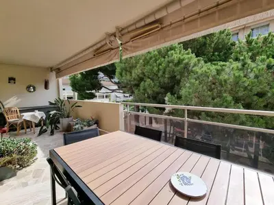 a wooden table and chairs on a balcony at 85m2 Grandes Terrasses - 2 chambres in Cannes