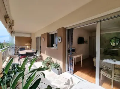 a room with a balcony with a bed and a table at 85m2 Grandes Terrasses - 2 chambres in Cannes