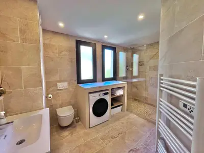 a bathroom with a washing machine and a toilet at LE TRAVOLTA avec merveilleuse terrasse, chic et lumineux à deux pas du centre-ville in Cannes