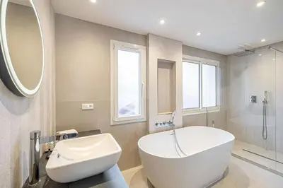 a bathroom with a large white tub and a sink at LE GRAND BOIS élégant et chaleureux avec balcon, au calme et à deux pas du centre-ville in Cannes