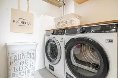 a washer and dryer in a laundry room at LE GRAND BOIS élégant et chaleureux avec balcon, au calme et à deux pas du centre-ville in Cannes