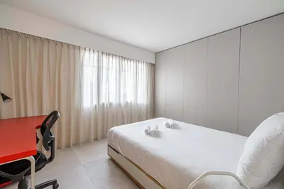 a bedroom with a bed and a red desk and a red chair at LE GRAND BOIS élégant et chaleureux avec balcon, au calme et à deux pas du centre-ville in Cannes