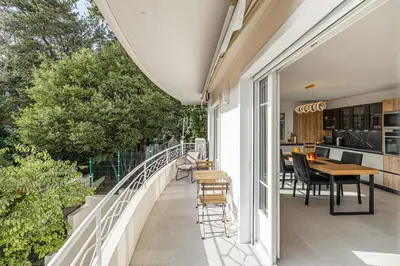 a balcony with a table and chairs on it at LE GRAND BOIS élégant et chaleureux avec balcon, au calme et à deux pas du centre-ville in Cannes