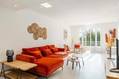 a living room with a couch and a table at LE GRAND BOIS élégant et chaleureux avec balcon, au calme et à deux pas du centre-ville in Cannes