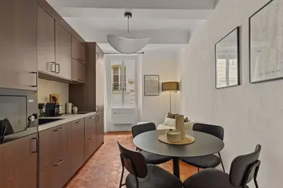 a living room with a table and chairs and a kitchen at Exceptionnel face Palais Cannes in Cannes