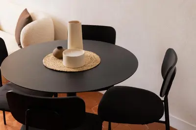 a round black table with black chairs and a vase at Exceptionnel face Palais Cannes in Cannes