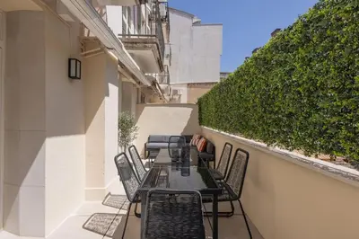a table and chairs on a balcony with a hedge at Extraordinaire avec terrasse in Cannes