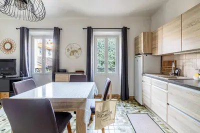 a kitchen with a table and some chairs and a sink at LE FORVILLE lumineux en plein centre, à deux pas du Palais, Croisette et plages in Cannes