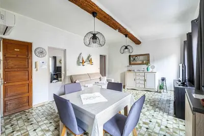 a kitchen and living room with a table and chairs at LE FORVILLE lumineux en plein centre, à deux pas du Palais, Croisette et plages in Cannes