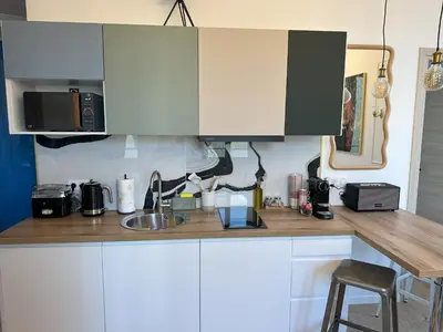 a kitchen with white cabinets and a counter top at Le cœur de Cannes in Cannes