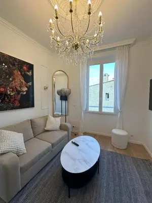 a living room with a couch and a chandelier at Le cœur de Cannes in Cannes
