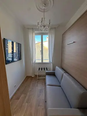a living room with a couch and a large window at Le cœur de Cannes in Cannes