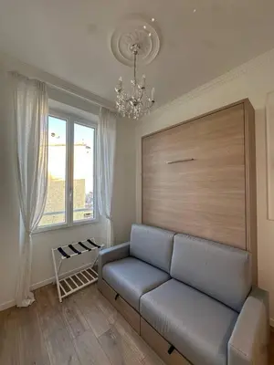 a living room with a couch and a window at Le cœur de Cannes in Cannes
