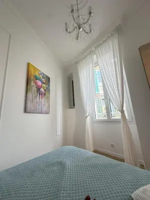a bedroom with a bed and a painting on the wall at Le cœur de Cannes in Cannes