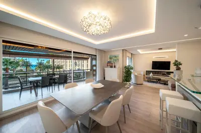 a dining room and living room with a table and chairs at REF 1924 - Cannes Croisette - Sea view apartment for rent in Cannes