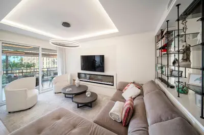 a living room with a couch and a tv at REF 1924 - Cannes Croisette - Sea view apartment for rent in Cannes