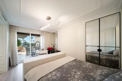 a bedroom with a bed and a balcony at REF 1924 - Cannes Croisette - Sea view apartment for rent in Cannes