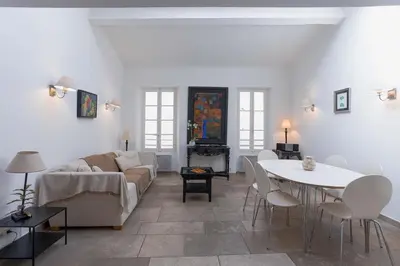 a living room with a couch and a table at Maison Julia- Triplex avec rooftop terrasse vue sur mer et cathédrale, 10 mins à pieds du palais et plages in Cannes