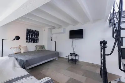 a bedroom with a bed and a flat screen tv at Maison Julia- Triplex avec rooftop terrasse vue sur mer et cathédrale, 10 mins à pieds du palais et plages in Cannes