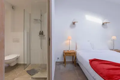 a bedroom with a bed and a shower and a toilet at Maison Julia- Triplex avec rooftop terrasse vue sur mer et cathédrale, 10 mins à pieds du palais et plages in Cannes
