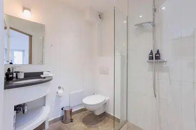 a white bathroom with a toilet and a shower at Maison Julia- Triplex avec rooftop terrasse vue sur mer et cathédrale, 10 mins à pieds du palais et plages in Cannes