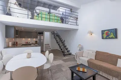 a living room with a couch and a table at Maison Julia- Triplex avec rooftop terrasse vue sur mer et cathédrale, 10 mins à pieds du palais et plages in Cannes