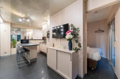 a large kitchen with a tv on the wall at Ciel d Azur avec terrasse en plein centre près de la Croisette in Cannes