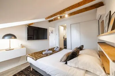 a bedroom with a large bed and a tv at 5 CARNOT - Beautiful apartment, 4 people, 150m from Palais des Festivals in Cannes