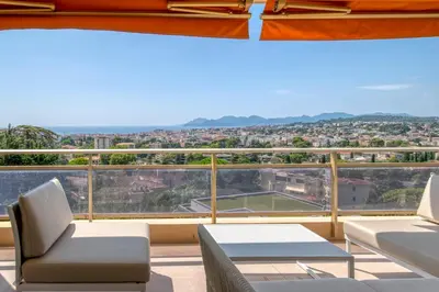 a balcony with chairs and a view of a tennis court at REF 1965 - Le Cannet - Sea view apartment for rent in Le Cannet