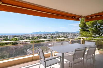 a white table and chairs on a balcony with a view at REF 1965 - Le Cannet - Sea view apartment for rent in Le Cannet