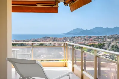 a balcony with a chair and a view of the city at REF 1965 - Le Cannet - Sea view apartment for rent in Le Cannet