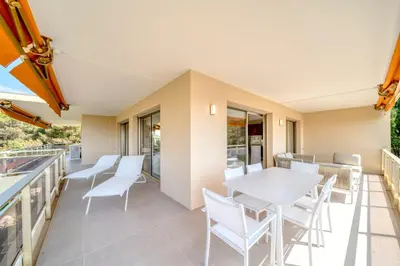 a patio with white chairs and a table on a balcony at REF 1965 - Le Cannet - Sea view apartment for rent in Le Cannet