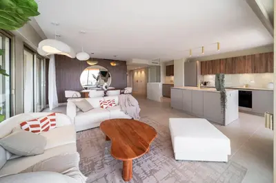 a living room with white furniture and a kitchen at REF 1965 - Le Cannet - Sea view apartment for rent in Le Cannet