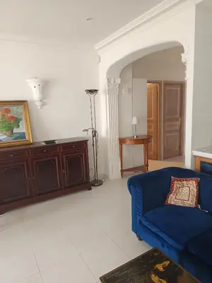 a living room with a blue couch and a table at La matoune in Cannes