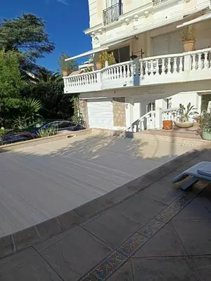 a white house with a balcony and a patio at La matoune in Cannes