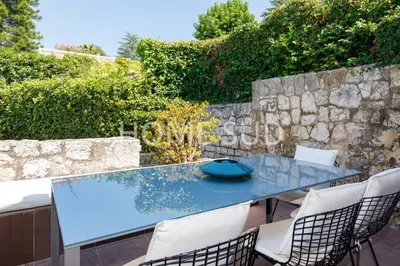 a blue table with chairs and a stone wall at Votre maison de vacances dans un écrin de verdure - Cannes in Cannes